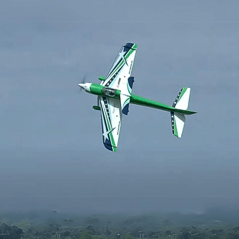 FMS F3A Explorer 1020mm PNP aerobatic RC plane in flight, white with green accents and stars.