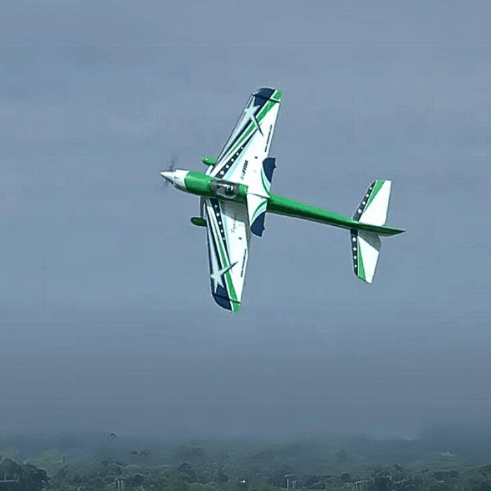 FMS F3A Explorer 1020mm PNP aerobatic RC plane in flight, white with green accents and stars.