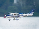 Blue and white Cessna 182 RC airplane soaring in the sky