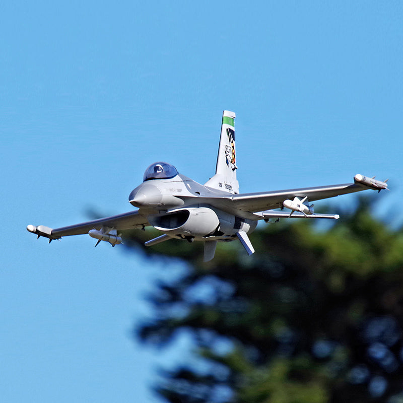 FMS 70mm F-16C Fighting Falcon model jet in flight, grey with USAF camouflage and tail art.