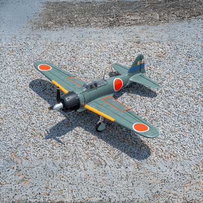 FMS 800mm Zero A6M3 V2 PNP airplane, green with red Hinomaru insignia and yellow wingtips, on gravel.