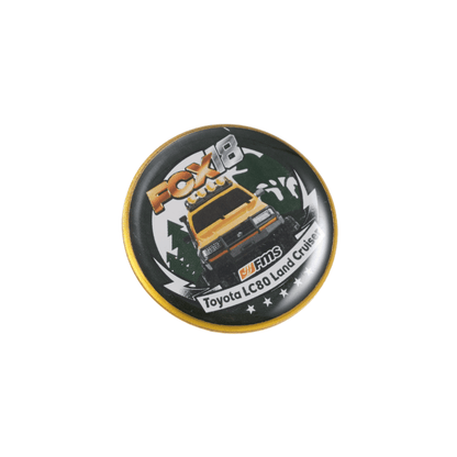 Metal pin showcasing a yellow Toyota LC80 Land Cruiser with FOX branding