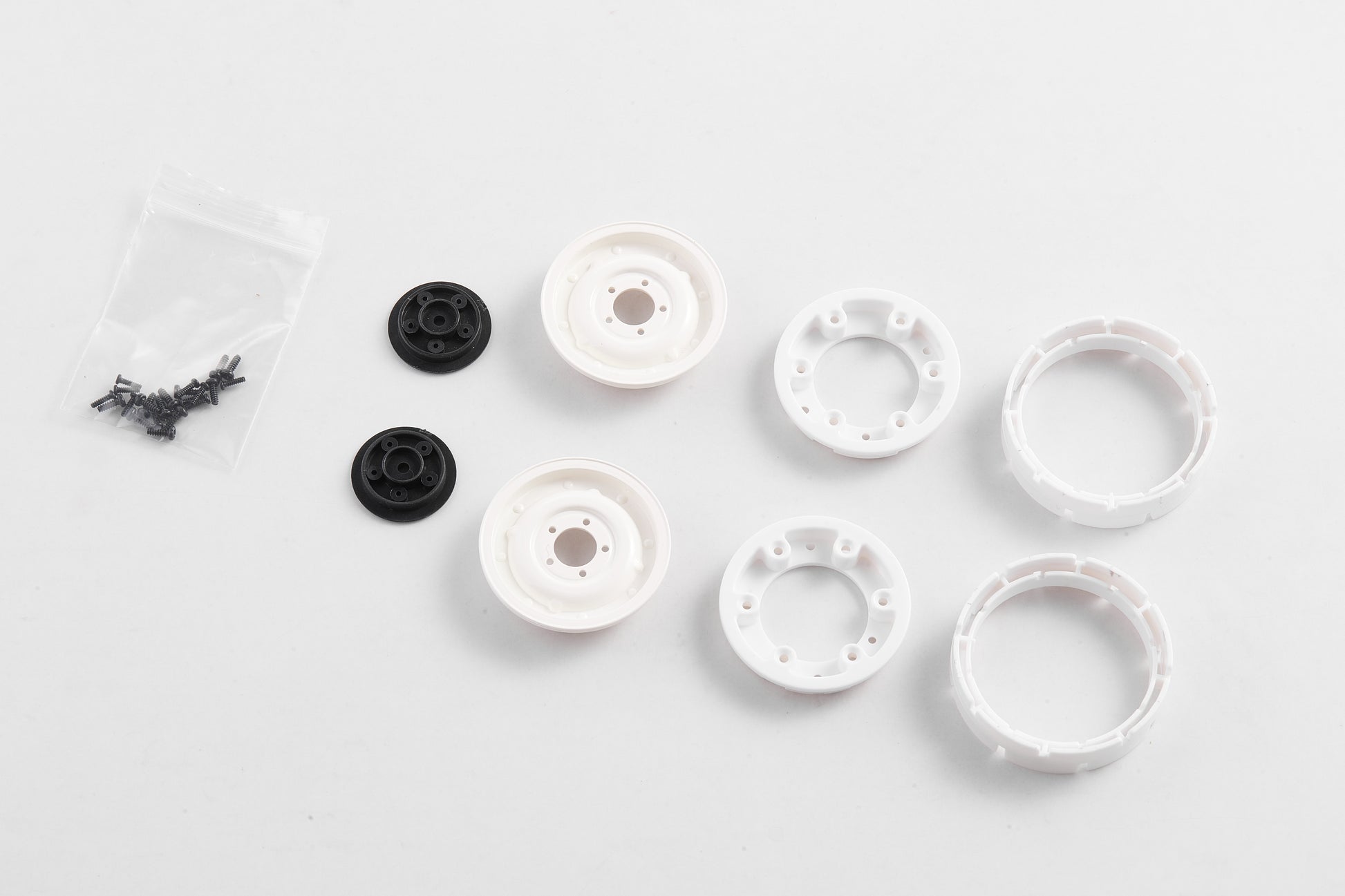 1:12 Land Rover wheel set with white rims, black adapters, and screws