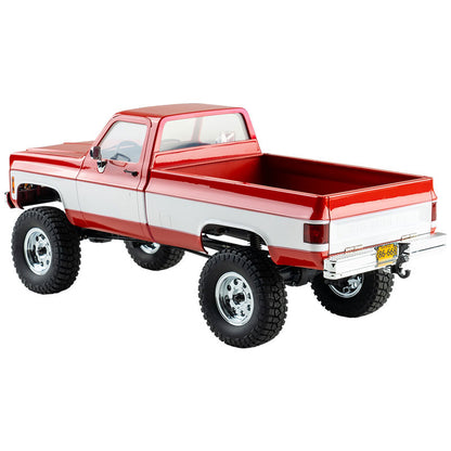 FMS 1:18 FCX18 Chevrolet K10 V2 RTR RC truck in red and white, featuring off-road tires and chrome wheels.