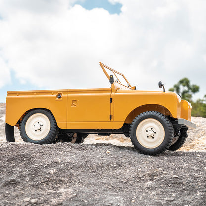 Yellow 1:12 FMS Land Rover Series II RTR toy vehicle on rocky terrain