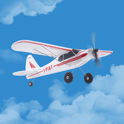 Model airplane with propeller against a blue sky with clouds