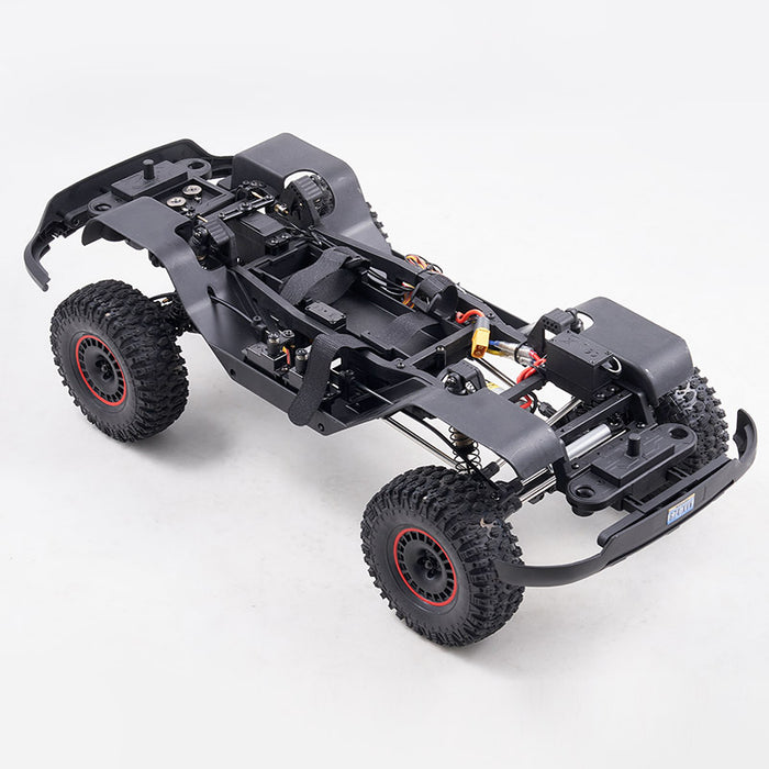 FMS 1:10 Canyon RS chassis with black rugged tires, visible suspension, steering servo, and motor components.