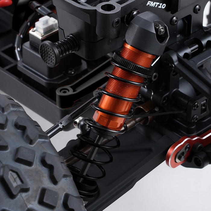 Orange oil-filled shock absorber with black coil springs on FMS 1:10 Colorado Basher RS.