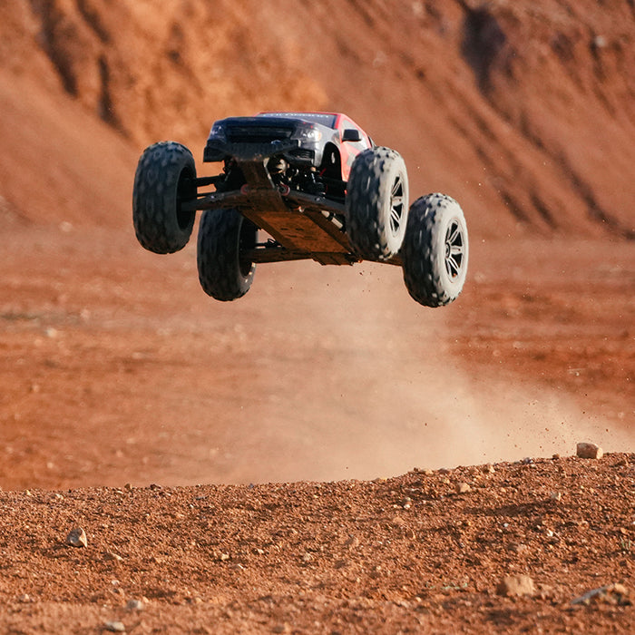 FMS 1:10 Brushless Chevrolet Colorado Basher RS 4WD RC truck airborne over dirt track.