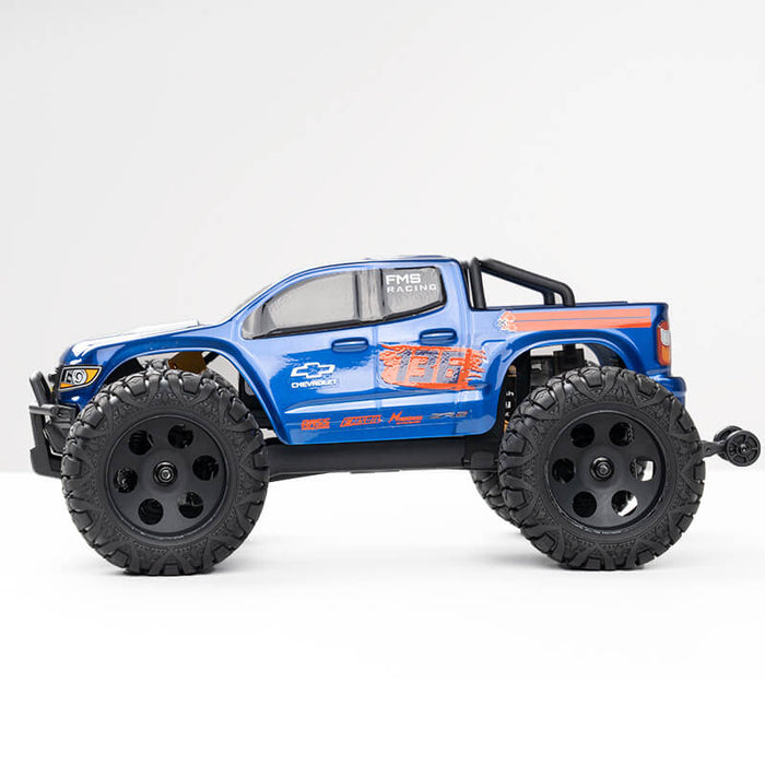 Blue FMS 1:24 FMT24 Chevrolet Colorado monster truck RTR with black wheels and racing graphics.
