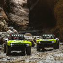 FMS 1:7 Ford Bronco RTR EB Brushless 4WD RS RC car in bright lime green, driving off-road through a rocky canyon.