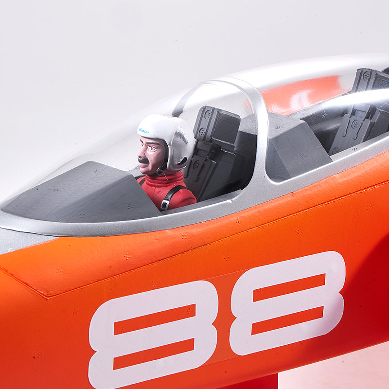 Close-up of FMS Super Scorpion V2 EDF jet cockpit with pilot, bright orange fuselage, and white '38' numbering.