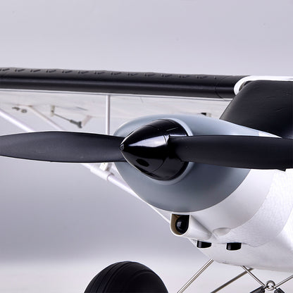 FMS 1300mm PA-18 Super Cub RC plane front view: black propeller, grey/white cowling, camera.