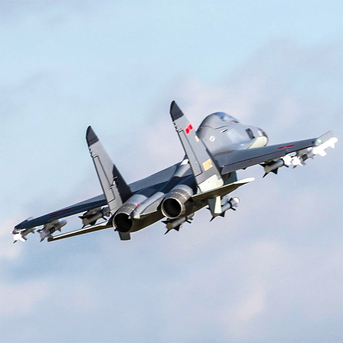FMS Twin 70mm EDF J-11 PNP model jet in flight with missiles attached.