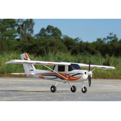 FMS 850mm Ranger RC plane, white with orange accents, on tarmac with greenery in background.