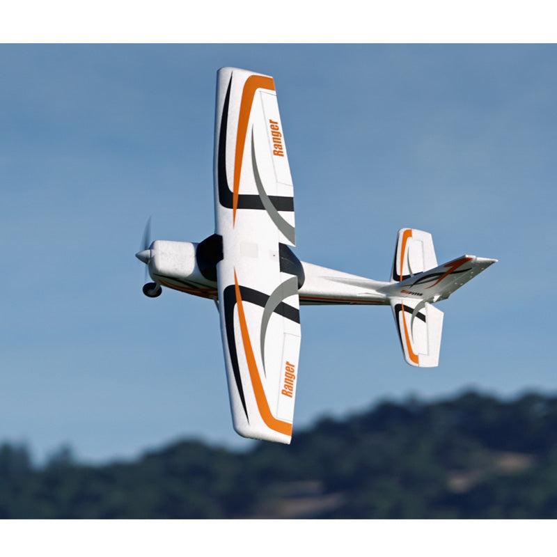 FMS 850mm Ranger RC airplane in flight with orange and black design