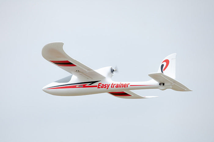FMS 1280mm Easy Trainer RC airplane in flight with red and black trim, ideal for beginners.