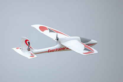 FMS 1280mm Easy Trainer RC airplane flying with red and black decals. Features pusher prop and "Easy trainer" text.