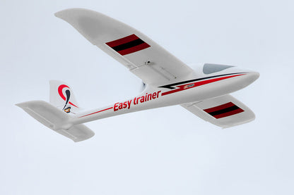 FMS 1280mm Easy Trainer RC plane, white with red and black accents, flying in the sky.