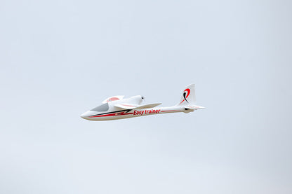FMS 1280mm Easy Trainer RC airplane in flight, white with red accents and "Easy trainer" text.
