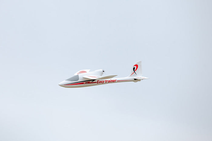 FMS 1280mm Easy Trainer RC airplane in flight, white with red accents and "Easy trainer" text.